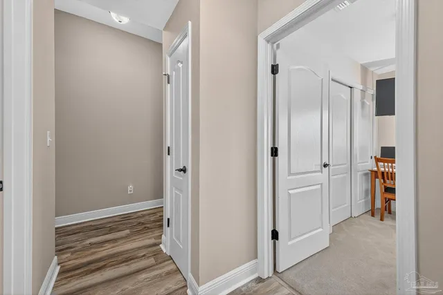 a view of a hallway with wooden floor and closet