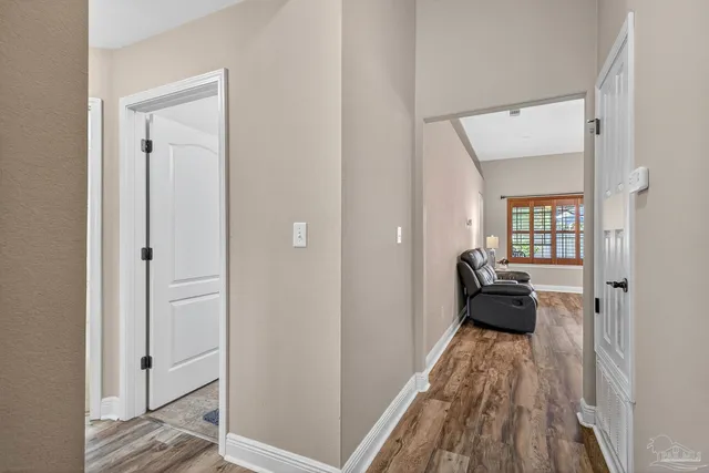 a view of a hallway with wooden floor and a bedroom