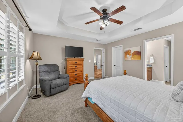 a spacious bedroom with a bed couch and window