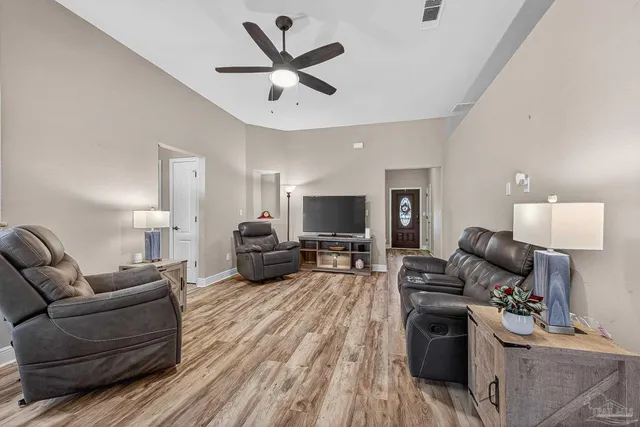 a living room with furniture or chandelier and a wooden floor