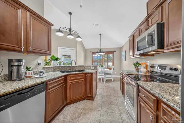 a kitchen with stainless steel appliances granite countertop a sink stove and cabinets