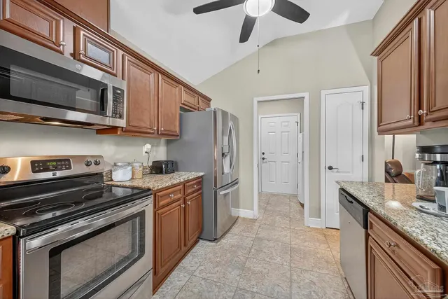 a kitchen with stainless steel appliances granite countertop a stove microwave and cabinets