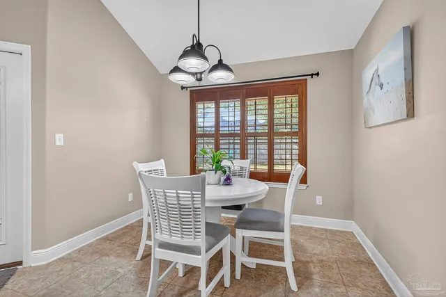 a dining room with furniture a chandelier and wooden floor