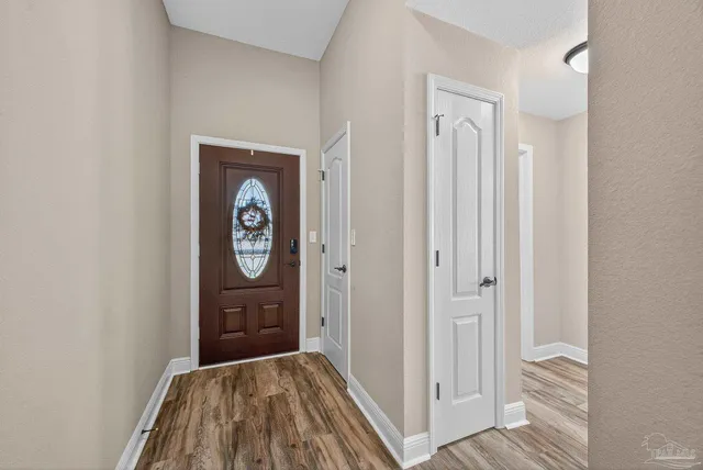 a view of a hallway with wooden floor and closet