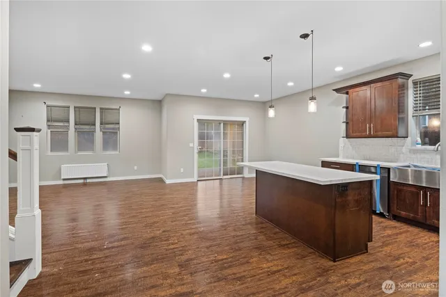 a large kitchen with stainless steel appliances granite countertop a large counter top a sink and a wooden floors