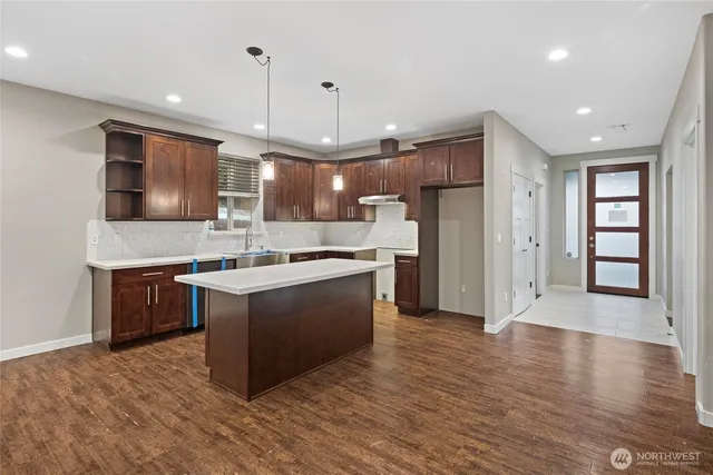a large kitchen with stainless steel appliances granite countertop a stove a sink and a refrigerator
