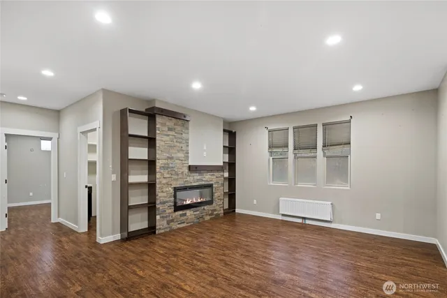 a view of empty room with wooden floor and windows