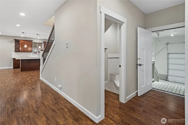 a view of a hallway with wooden floor and staircase