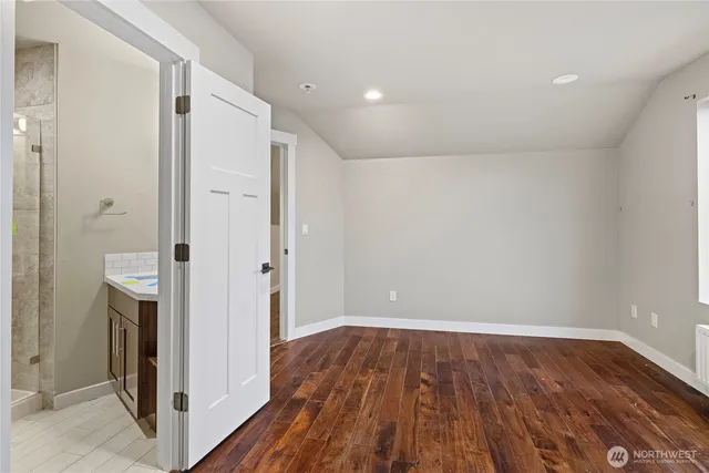a view of a hallway with wooden floor and closet area