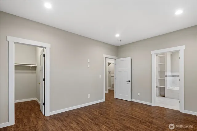 an empty room with wooden floor & closet area
