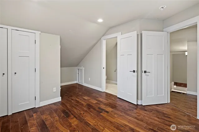 a view of a hallway with wooden floor and closet area