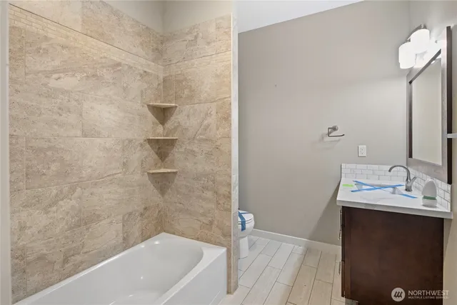 a bathroom with a sink a toilet and shower