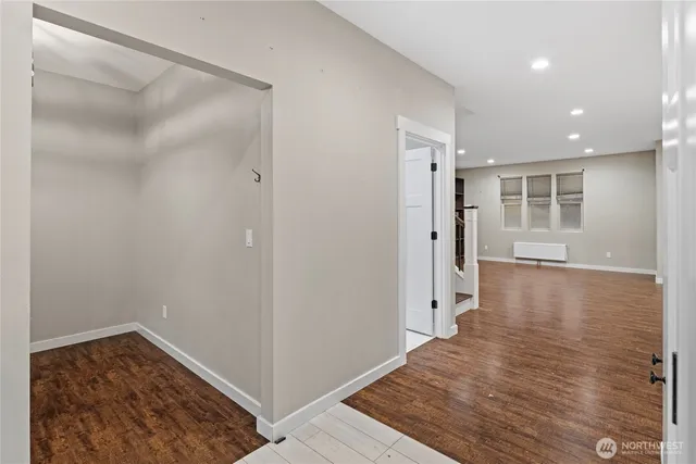 a view of a hallway with wooden floor and a cabinet