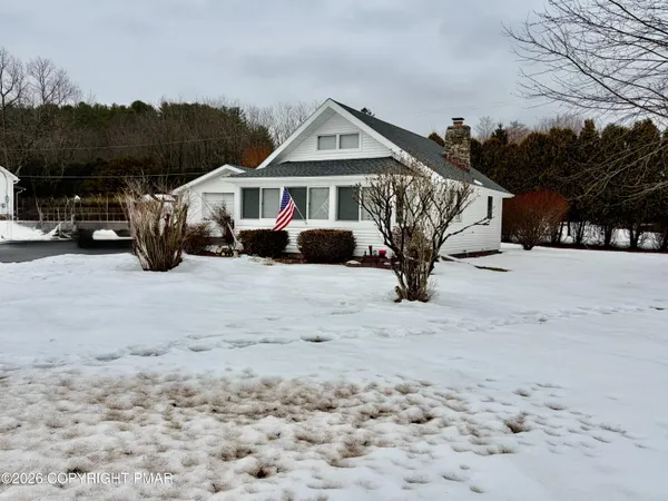 a view of a house with large trees in front of house