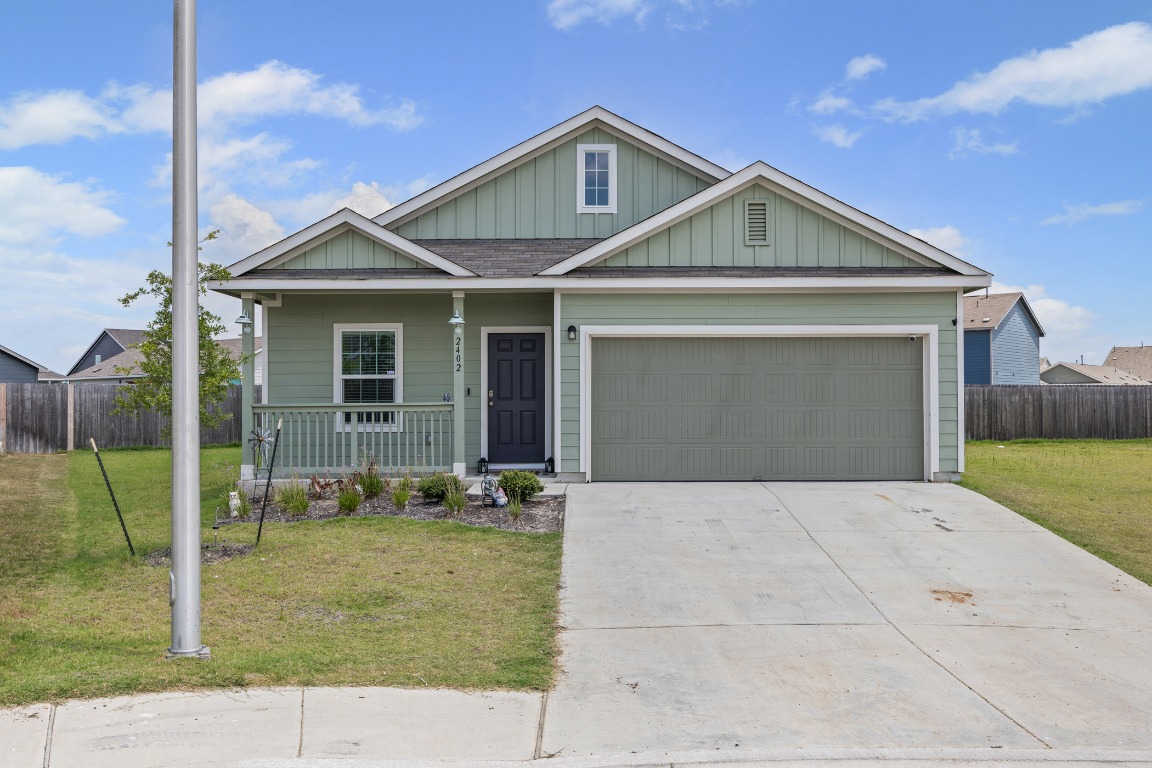 View of front facade with a porch, concrete driveway, a garage, and board and batten siding
