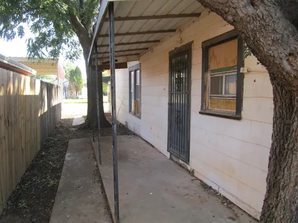 a view of a brick house with a large tree