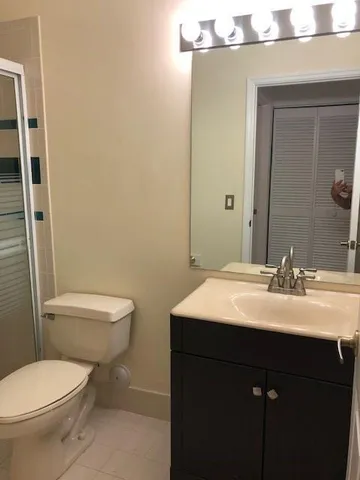 a bathroom with a toilet a sink and mirror