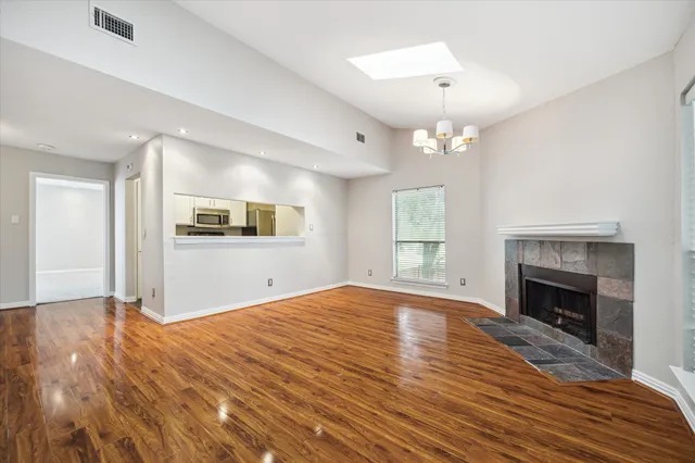 a view of empty room with wooden floor and fireplace