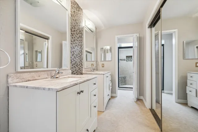 a spacious bathroom with a granite countertop sink and a mirror