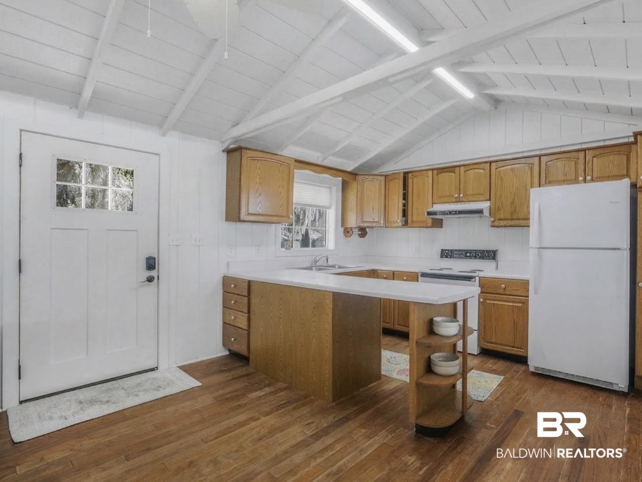 11326 County Road 26 Foley, AL 36535 - Photo 15 of 20 Kitchen with light countertops, white appliances, a peninsula, dark wood finished floors, and wood finish cabinets