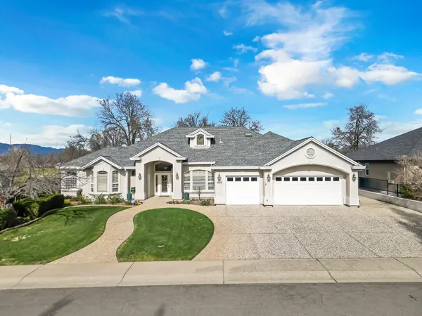 a view of a big house with a big yard and large tree