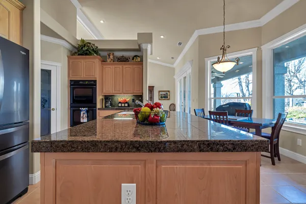 a kitchen with stainless steel appliances granite countertop a stove refrigerator and microwave