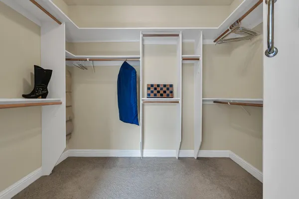 a view of walk in closet with clothes and shoes