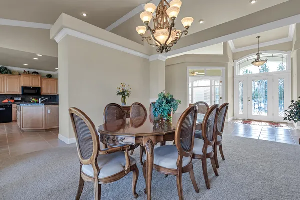 a dining room with furniture a chandelier and wooden floor