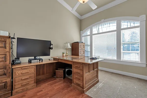 a view of a workspace with furniture and a window