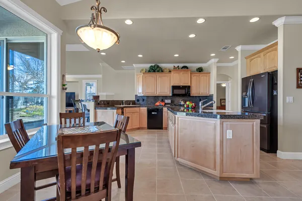 a kitchen with stainless steel appliances kitchen island granite countertop a refrigerator and microwave
