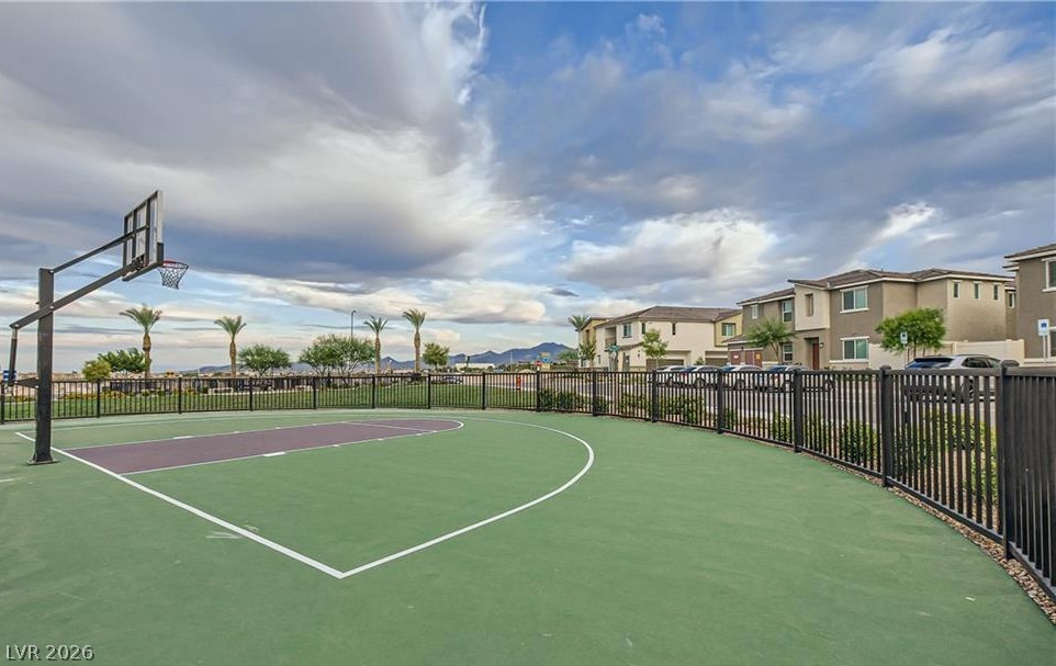 12110 Midnight Pine Road, Unit 3 Las Vegas, NV 89183 - Photo 2 of 13 An inviting basketball court offers recreation, set against a backdrop of distant mountains and a community of homes.