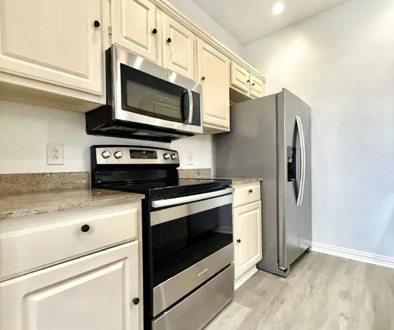 a kitchen with stainless steel appliances a stove microwave and sink