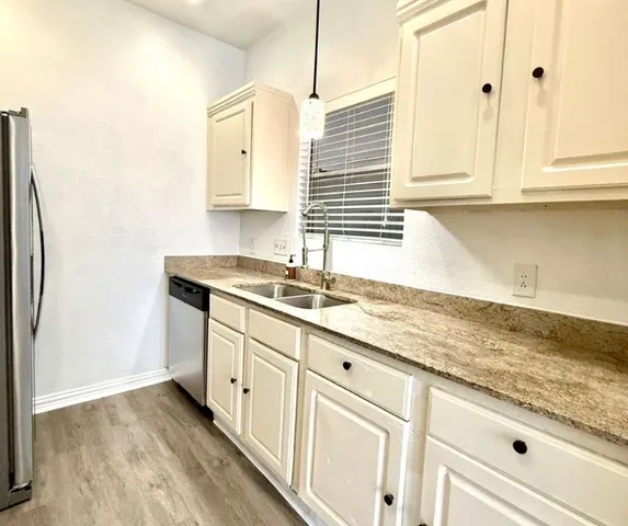 a kitchen with granite countertop white cabinets and white appliances