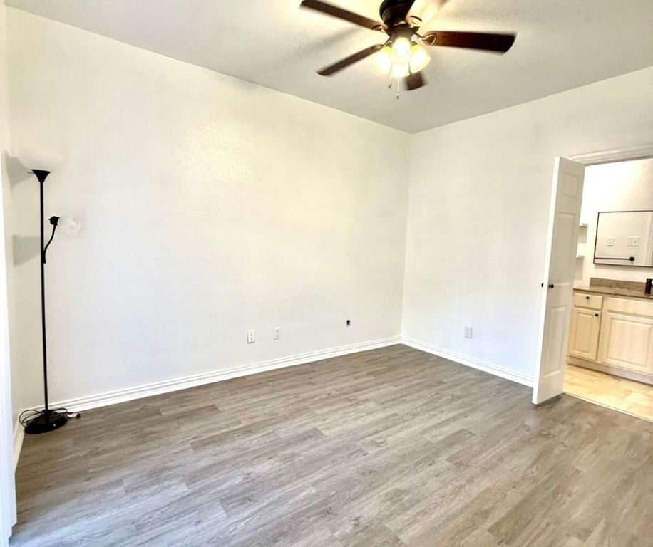 12166 Metric Boulevard, Unit 143 Austin, TX 78758 - Photo 6 of 11 wooden floor in an empty room with a window