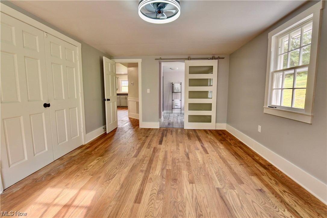9734 Edwards Ridge Road Southeast Uhrichsville, OH 44683 - Photo 15 of 35 Hardwood floored spare room featuring a barn door