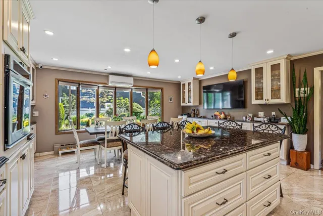 a kitchen with granite countertop a stove and living room view