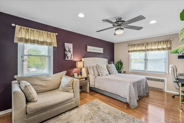 a bedroom with a large bed and windows
