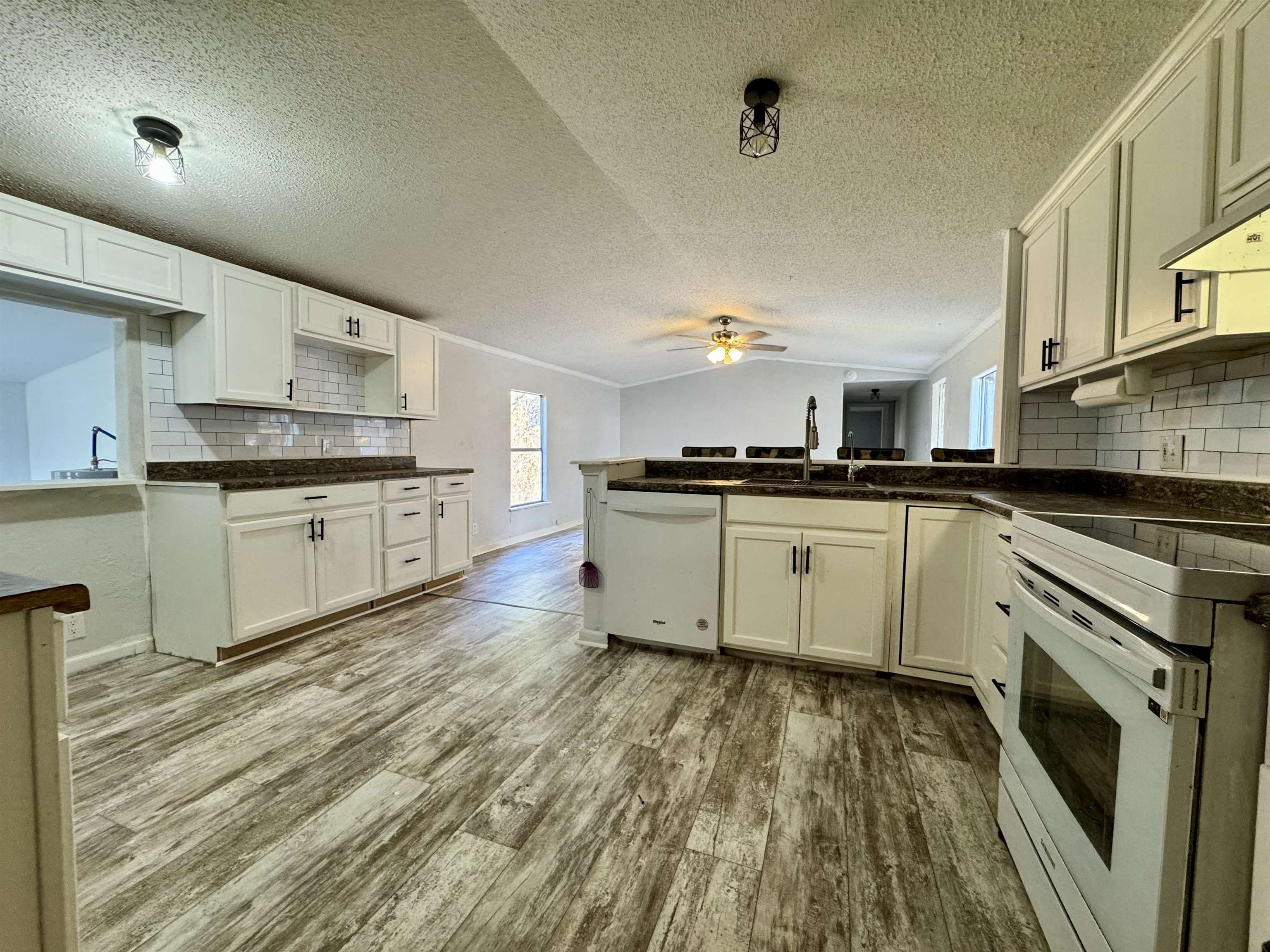 855 Beason Drive Morris Chapel, TN 38361 - Photo 6 of 21 a kitchen with stainless steel appliances granite countertop a stove top oven a sink dishwasher and white cabinets with wooden floor