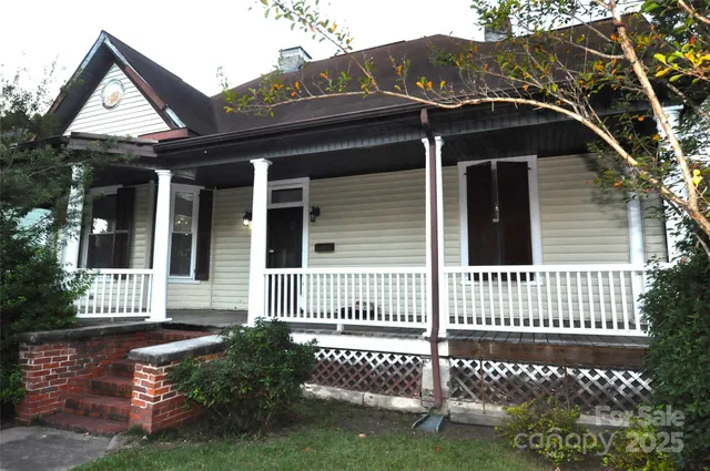 a view of a house with a small yard and wooden fence