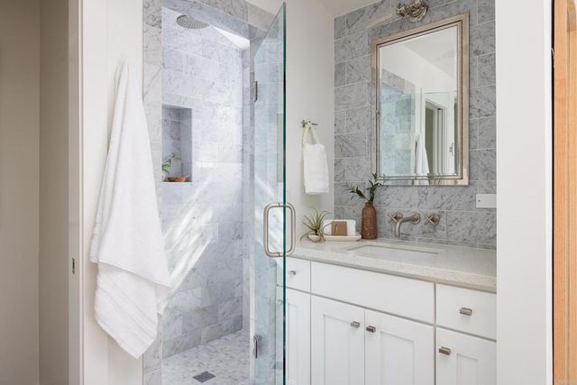 a bathroom with a granite countertop sink vanity and mirror