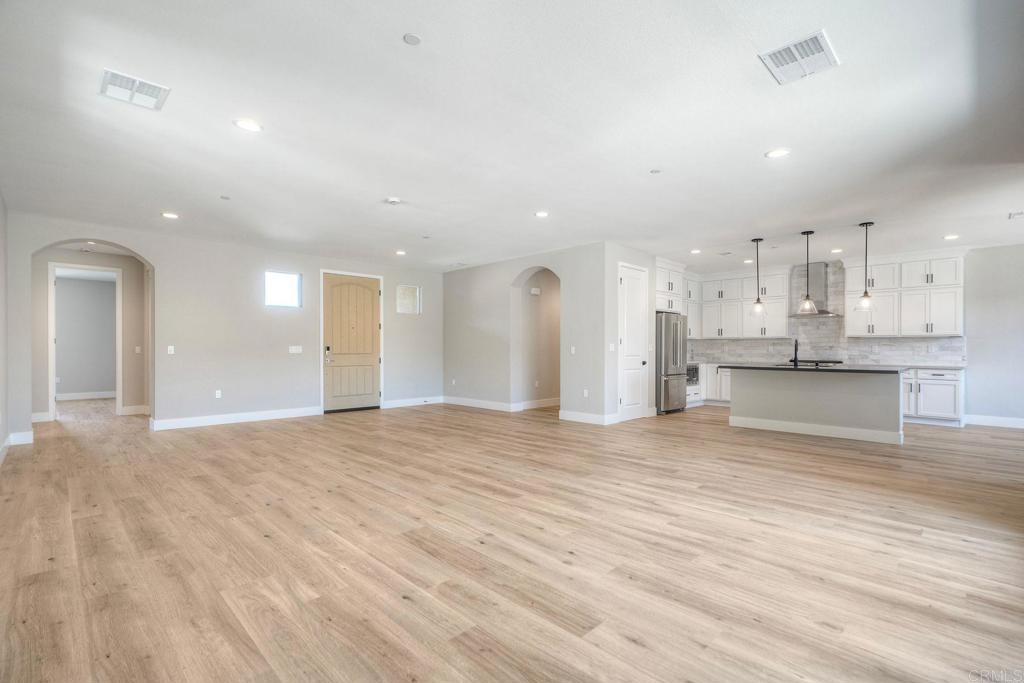 12073 Via Trevi, Unit LOT 2 Lakeside, CA 92040 - Photo 18 of 33 a view of kitchen with kitchen island white cabinets and wooden floor