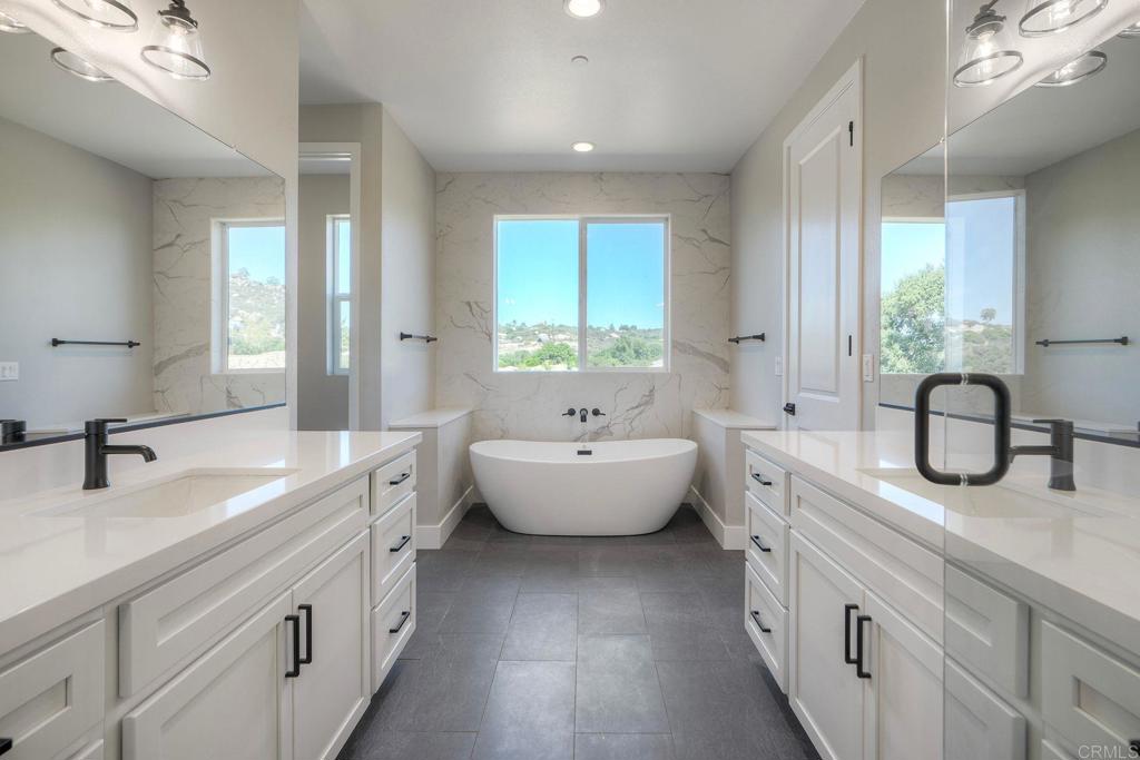 12073 Via Trevi, Unit LOT 2 Lakeside, CA 92040 - Photo 26 of 33 a spacious bathroom with double vanity a large mirror a vanity a bathtub and next to a window