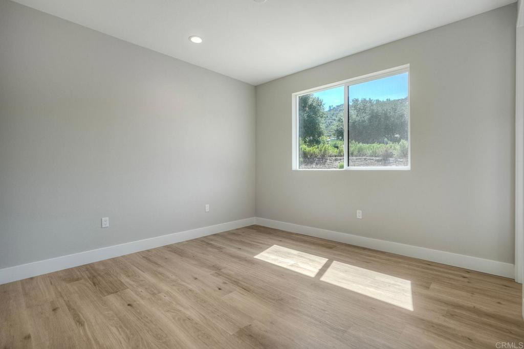 12073 Via Trevi, Unit LOT 2 Lakeside, CA 92040 - Photo 30 of 33 an empty room with wooden floor and windows