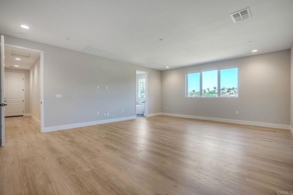 12073 Via Trevi, Unit LOT 2 Lakeside, CA 92040 - Photo 9 of 33 an empty room with wooden floor and windows