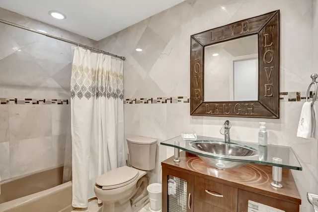 a bathroom with a granite countertop sink toilet and shower