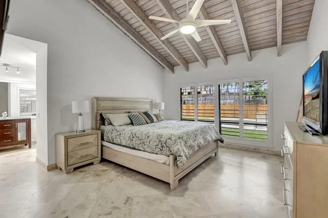 a spacious bedroom with a bed and a flat screen tv