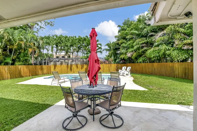 a view of a backyard with table and chairs and potted plants