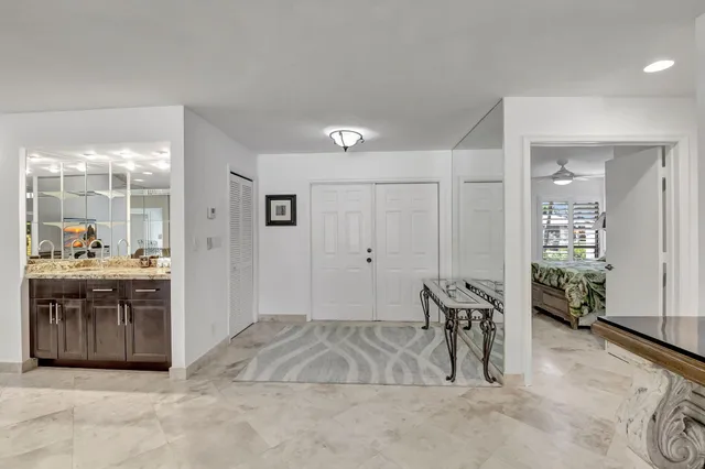a spacious bathroom with a granite countertop sink a mirror and a tub