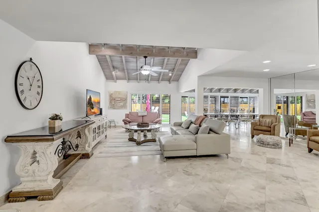 a living room with furniture a clock and a large window