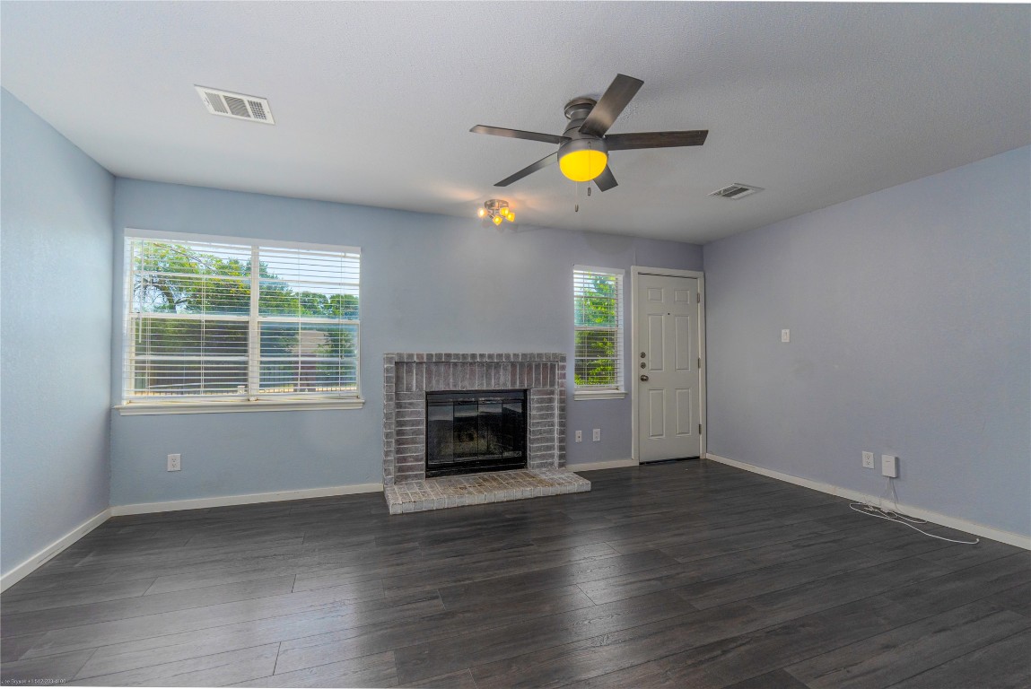 1845 River Crossing Circle, Unit C Austin, TX 78741 - Photo 1 of 28 an empty room with windows and fireplace